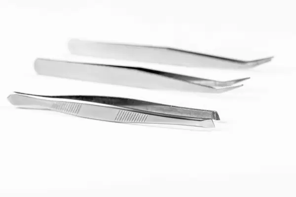 Three metal tweezers on a white background (Flip 2019)