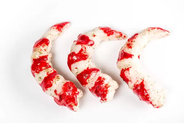 Three peeled shrimp tails, top view