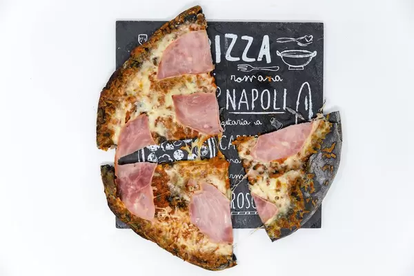 Three pieces of prosciutto pizza with black active coal crust