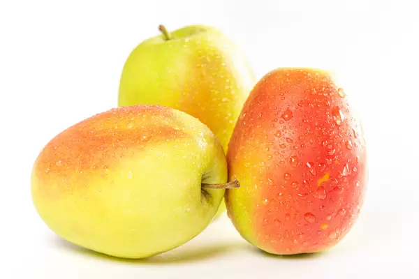 Three ripe apples on a white background