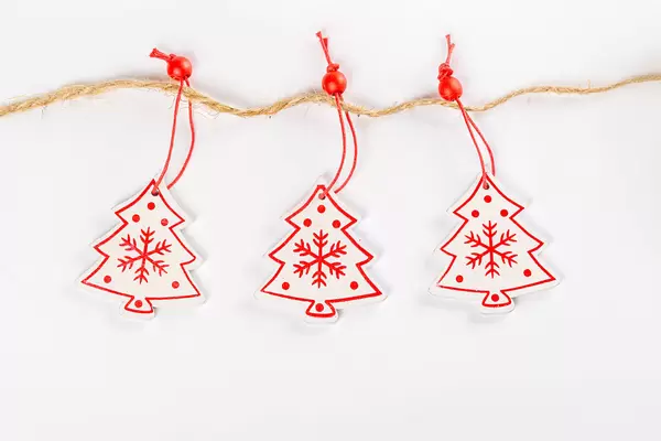 Three wooden Christmas trees toys hang on a rope