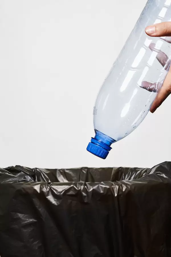 Throwing a plastic bottle into trash can
