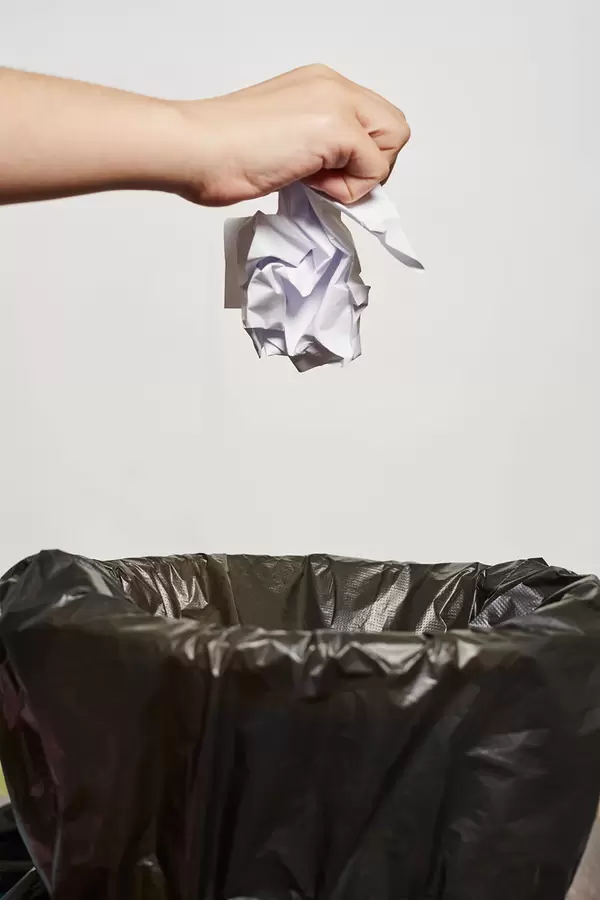 Throwing away crumpled paper into a trash can