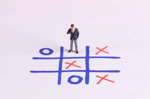 Tic Tac Toe game and miniature businessman