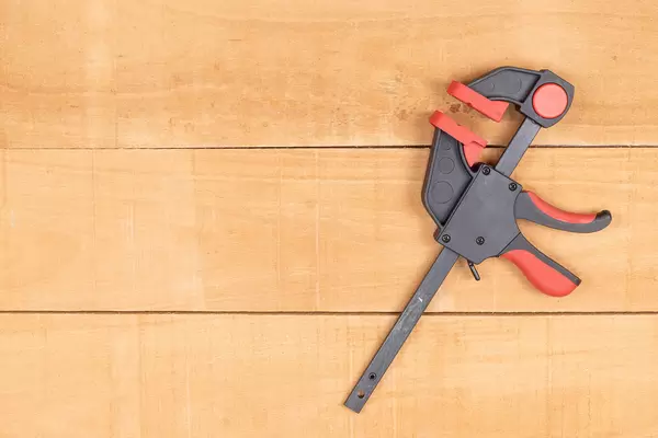 Tightening Woodworking Clamp with copy space above table