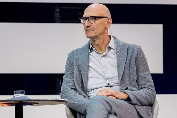 TIm Höttges in der Nahaufnahme auf der Bühne sitzend