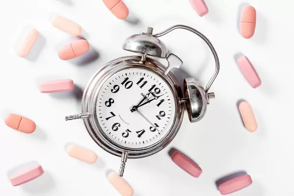 TIme for taking medication: pills and an alarmclock