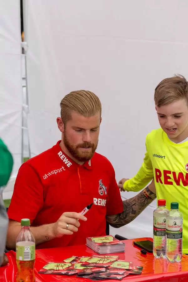 Timo Horn signiert Autogrammkarte für jungen Fan