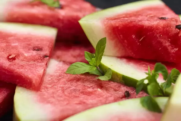 Tinny slices of fresh lemon with mint leafs