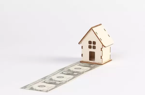 Tiny house with dollar banknotes