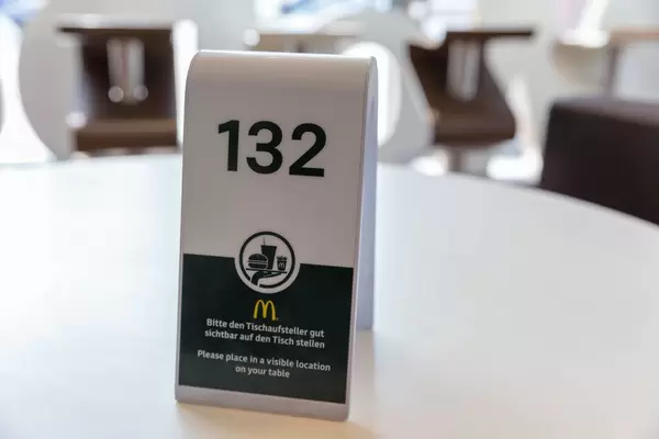 Tischaufsteller bei McDonalds wird als Platzhalter für die Essensbestellung auf dem weißen Tisch aufgestellt