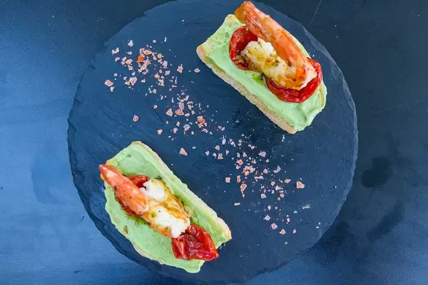 Toasted bread with king prawns, avocado creme sauce and dried tomatoes at Q11, Pollença. Top view