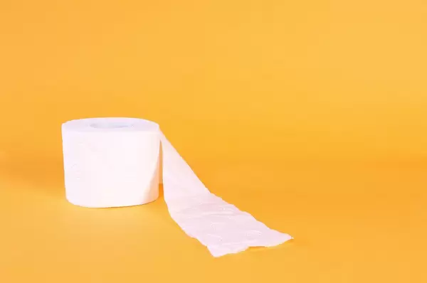 Toilet paper on orange background