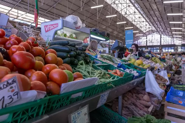 Tomaten, Gurken, Schalotten, Erbsen am Gemüsestand im Timeout Market in Lissabon