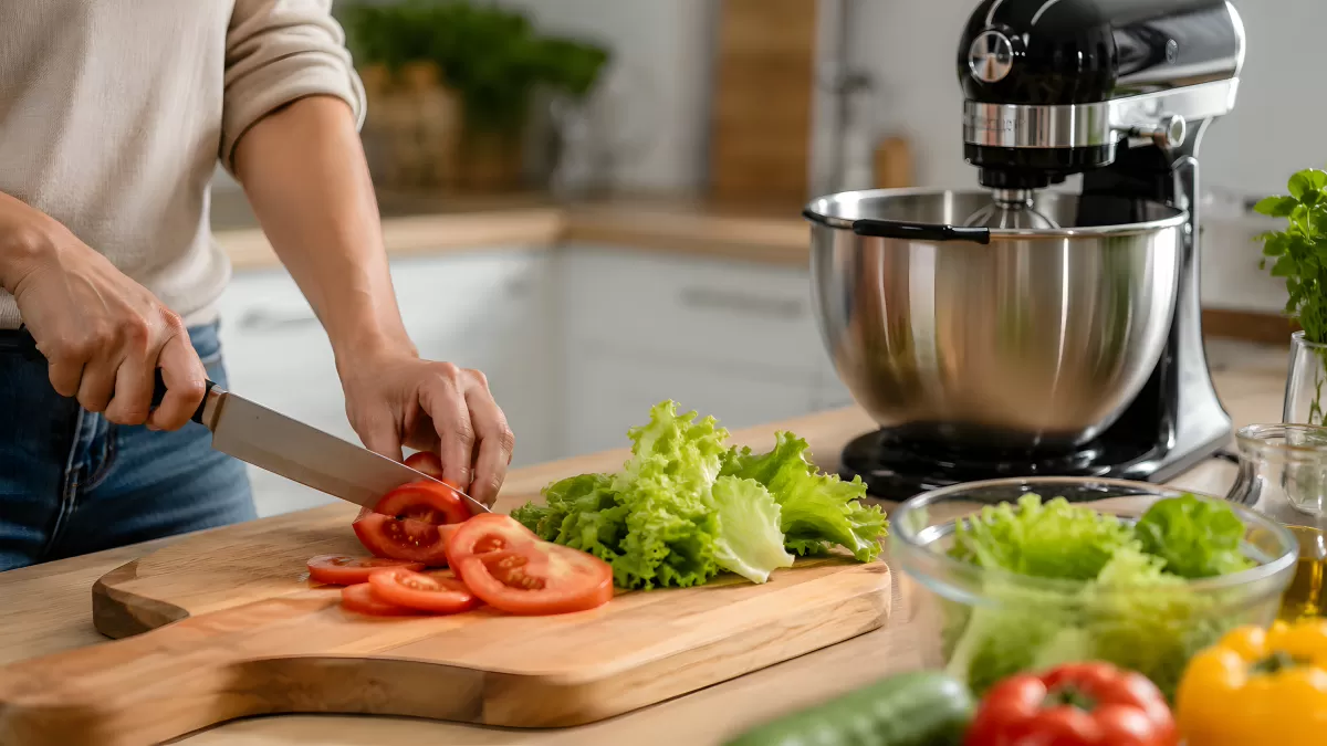 Tomaten schneiden auf Holzbrett in heller Küche