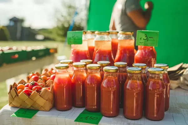 Tomatensaft in Glasflaschen, neben frischen Tomaten