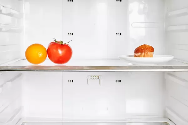 Tomato, lemon fruit and a cake in the fridge