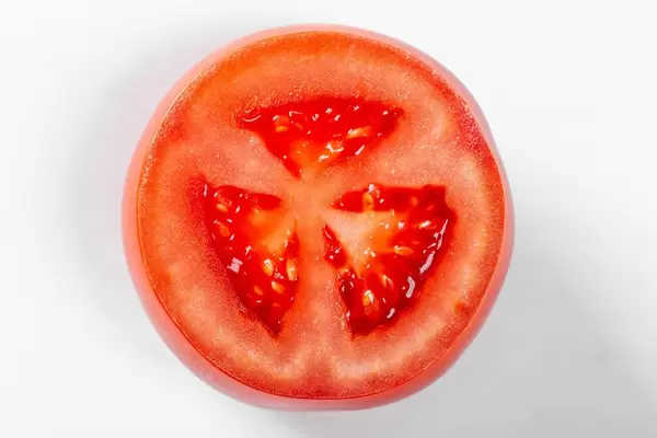 Tomato slice on white background, top view