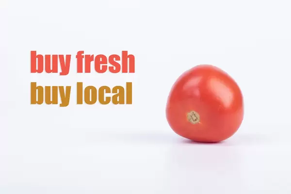 Tomato with Buy fresh Buy local text on white background