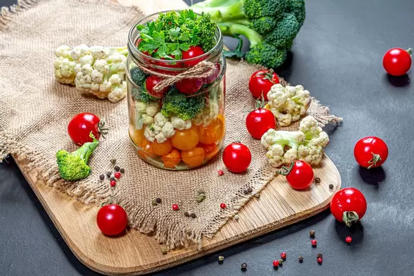 Tomatoes, cauliflower, broccoli and spices in a jar and on a table with burlap (Flip 2019)