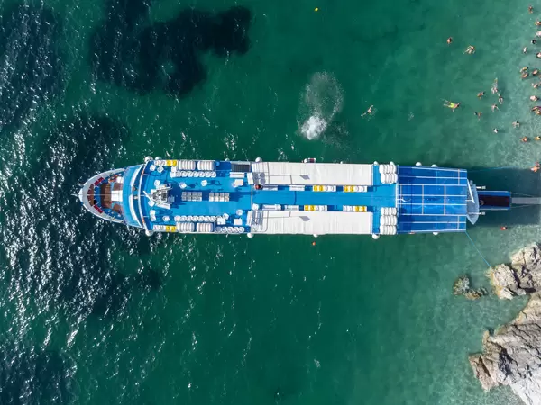 Top aerial view of cruise ship Elisabet surrounded by tourists in the waters of Kastani beach on Skopelos