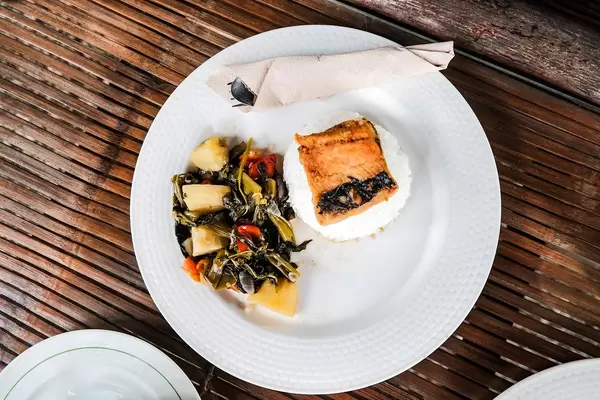 Top shot of a milkfish dish with vegetables on side