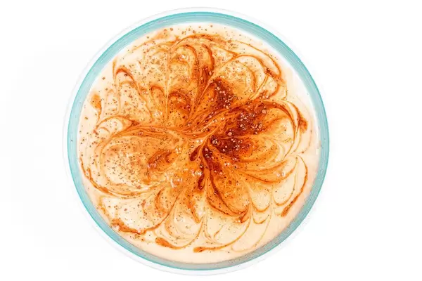 Top view, a bowl of cottage cheese and yogurt dessert with cocoa