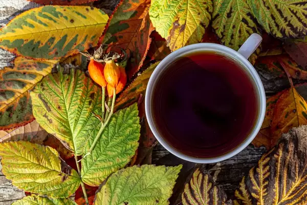 Top view a Cup of tea surrounded by colorful leaves (Flip 2019)