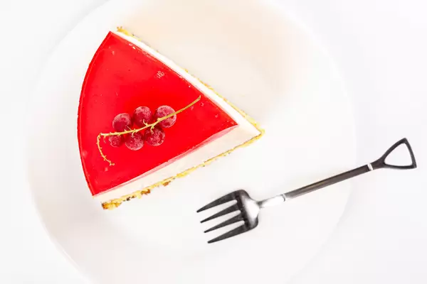 Top view, a slice of raspberry cheesecake with currant berries