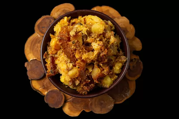 Top view, baked potatoes with meat, onions and carrots in a bowl
