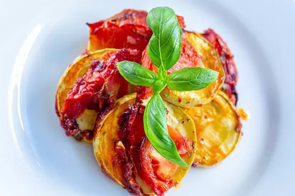 Top view baked zucchini with tomato sauce and fresh Basil