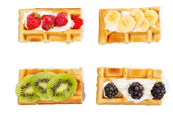 Top view, belgian waffles with strawberries, kiwi, banana and blackberries