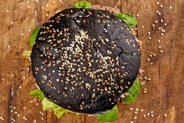 Top view, black burger on wooden board