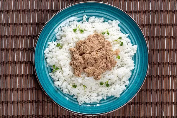 Top view boiled rice with tuna in green plate