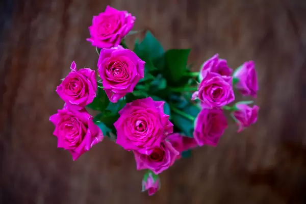 Top View Bokeh Photo of Bunch of Pink Roses with Wooden Background