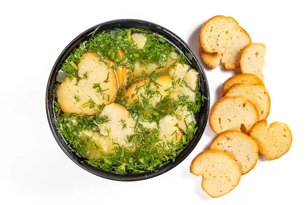 Top view, bowl of soup with croutons and herbs