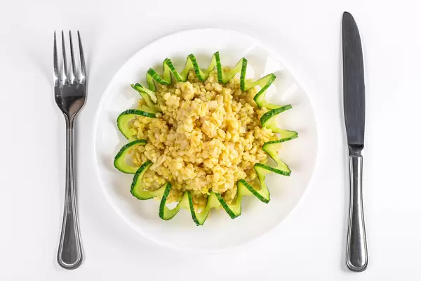 Top view, bulgur porridge with cucumber spiral