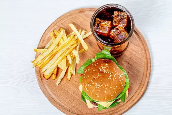 Top view Burger, fries and iced drink on round kitchen Board (Flip 2019)