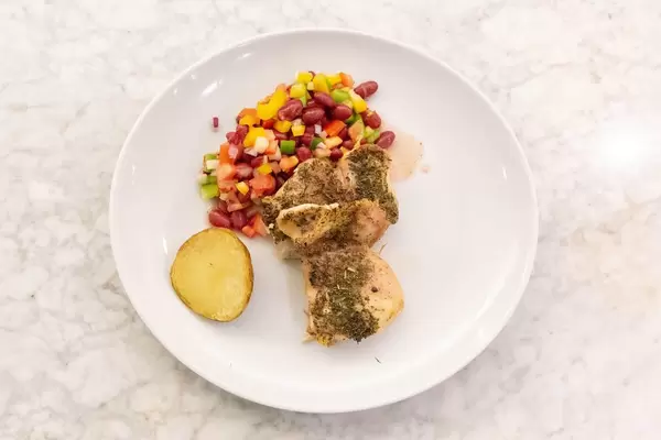 Top View - Chicken in herb sauce, baked potato and mixed bean salad