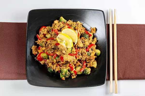 Top view chicken pieces with vegetables and mushrooms in spicy sauce