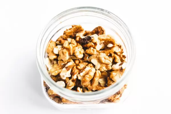 Top view close up of jar of walnuts white background