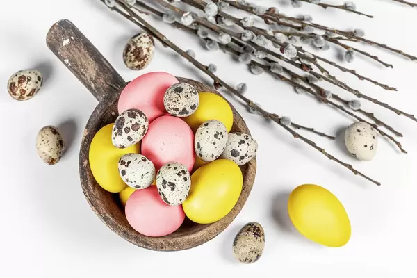 Top view, colored eggs with willow branches on a white background (Flip 2020)