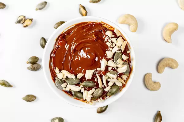 Top view dessert with condensed milk, cashews and pumpkin seeds on a white background (Flip 2019)