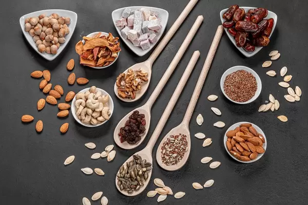 Top view dried fruits, nuts and seeds on a black background. Healthy food concept