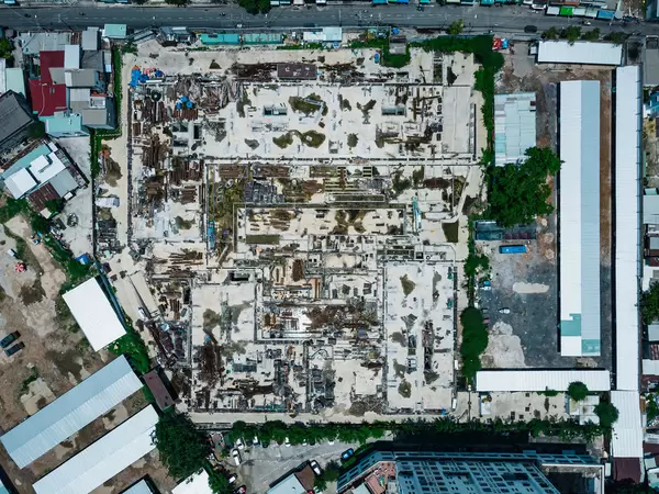 Top View Drone Photo of a Large Construction Side next to a Street with many Materials laying around in Ho Chi Minh City, Vietnam
