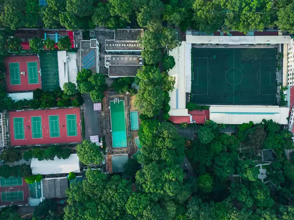 Top View Drone Shot of a Sports Facility with several Tennis Courts, Swimming Pool, Football Stadium surrounded by Tao Dan Park in Ho Chi Minh City, Vietnam