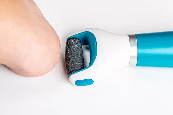 Top view, electric roller file for removing coarse skin of the heel and a woman's leg
