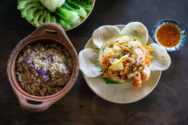 Top View Food Photo of Cooked Vegetables, Fish Fried Rice in Clay Pot, Pomelo Salad with Shrimp Chips, Shrimps and Peanuts in a Vietnamese Restaurant