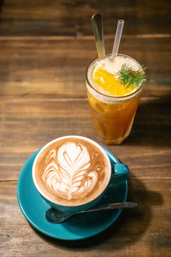Top View Food Photo of Orange Cinnamon Tea and Cappuccino on a Wooden Table