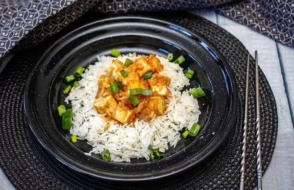 Top View Food Photo of Rice with Tofu, Green Onions and Peanut Sauce with Chopsticks